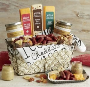 A gift assortment of snack size sausages, bars of cheese, mustards, nuts and trail mix in a rustic wire basket.