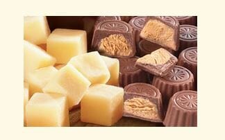 Chunks of cheese next to chocolate and peanut butter candies.
