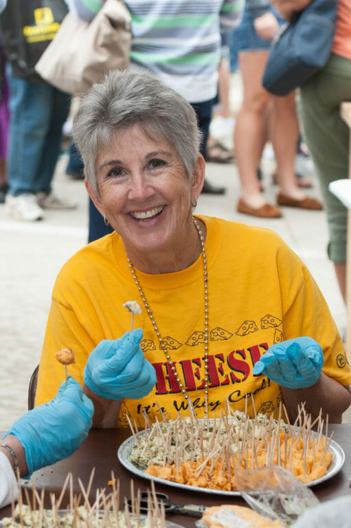 A smiling lady serving samples of cheese at Cheese Days in Monroe, Wisconsin.