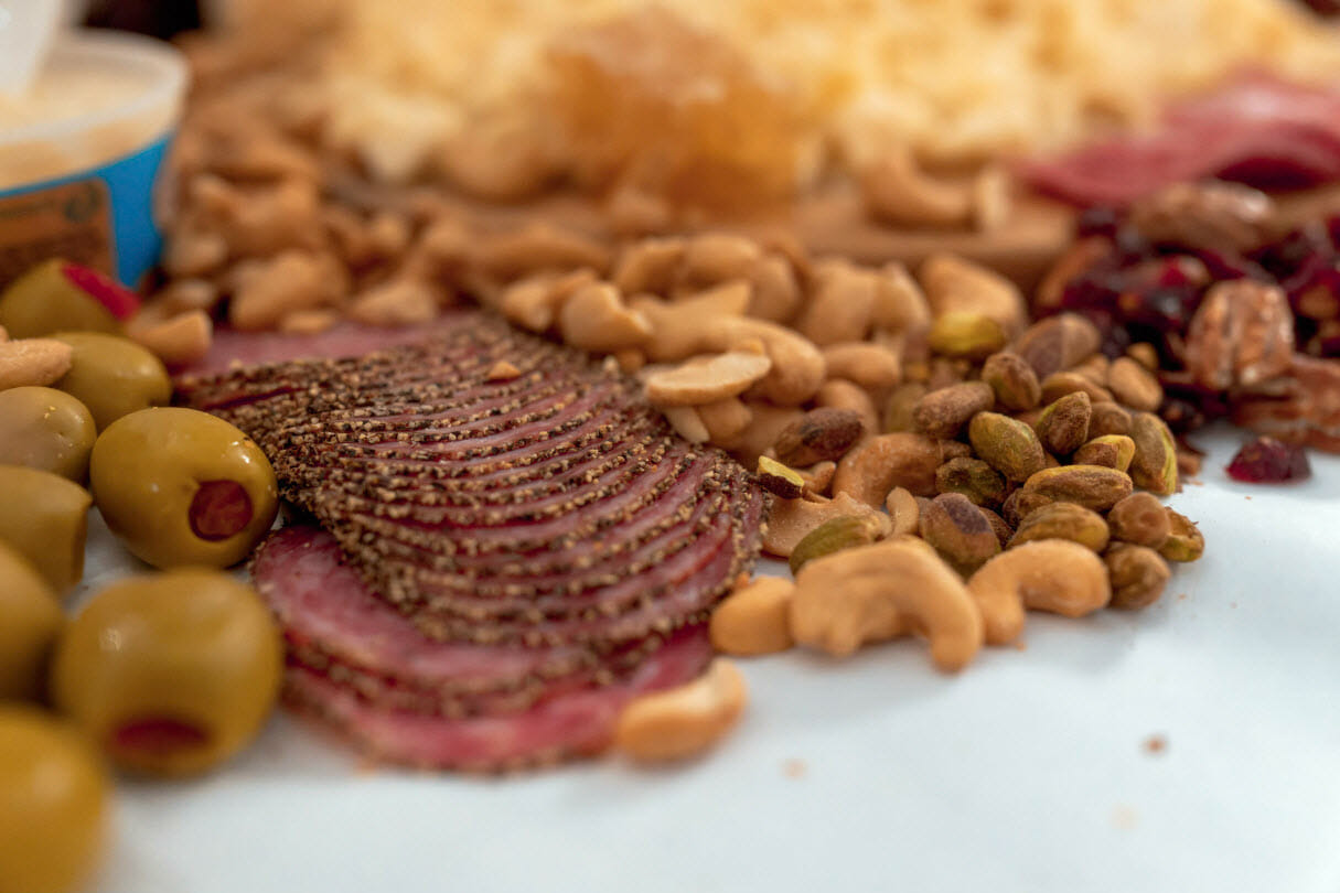 Salami food pairings with green olives and pistacios